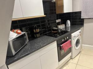 a kitchen with a stove and a washing machine at Holloway one bedroom apartment in London