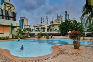 a person in a swimming pool in a city at 2BR Magnificent View Apartment at ITC Kuningan in Jakarta