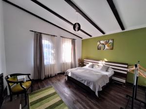 Un dormitorio con una cama y una pared verde. en Magic Apartments Hunedoara, en Hunedoara
