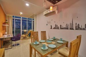 a dining room with a table with chairs and a kitchen at 2BR Magnificent View Apartment at ITC Kuningan in Jakarta