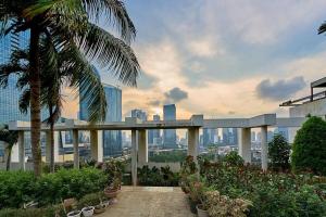 a view of a city from a building with plants at 2BR Magnificent View Apartment at ITC Kuningan in Jakarta
