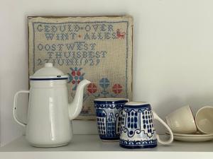 a shelf with three blue and white vases on it at Hof van Krijn in Zoutelande