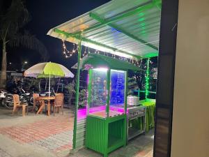 einem grünen Stand mit einem Aquarium und einem Regenschirm in der Unterkunft Hotel Angel Assam in Tezpur
