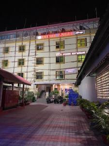 un gran edificio blanco con un letrero rojo. en Hotel Angel Assam, en Tezpur
