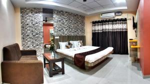 een slaapkamer met een groot bed en een stoel bij Hotel Angel Assam in Tezpur