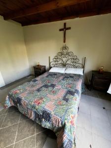 um quarto com uma cama com uma cruz na parede em A CAZON QUITADO em Saladillo
