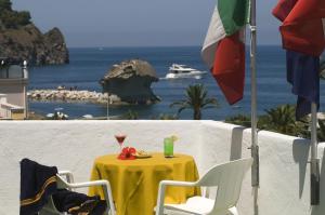 a table with a yellow table cloth and a drink on it at Hotel Villa Angelica in Ischia