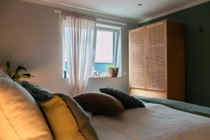 a bedroom with a bed with pillows and a window at Idyllische Ferienwohnung im Kraichgau in Sinsheim