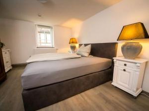 een slaapkamer met een groot bed en een tafel met een lamp bij Country house at the castle park in Brakel