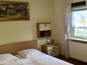 a bedroom with a bed and a picture on the wall at Holiday home Tachbachtal in Themar