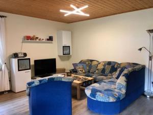 a living room with a blue couch and a table at Holiday home Tachbachtal in Themar