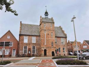 an old brick building with a cross on top of it at Nordwind Modern retreat in Norddeich