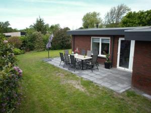 patio ze stołem i krzesłami na podwórku w obiekcie Holiday apartment Lavender w mieście Sint Maartensvlotbrug