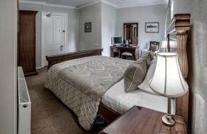 a bedroom with a bed and a dresser at Invergarry Hotel in Invergarry