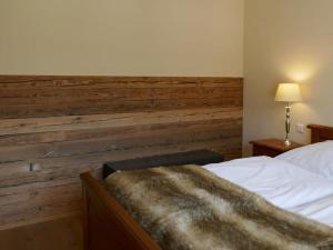 a bedroom with a wooden accent wall and a bed at Bodenschneid Suites Wallbergblick in Rottach-Egern