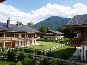 a resort with a large yard with houses and mountains at Bodenschneid Suites Wallbergblick in Rottach-Egern