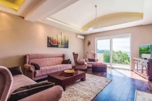 a living room with a couch and a table at Pool Villa Panorama Mojdež - Happy Rentals in Igalo