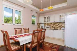 a kitchen with a table and chairs and a refrigerator at Pool Villa Panorama Mojdež - Happy Rentals in Igalo