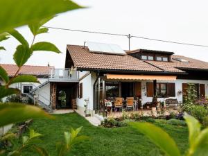 ein Haus mit einer Veranda und einer Terrasse mit Stühlen in der Unterkunft Chic holiday apartment in Oy-Mittelberg