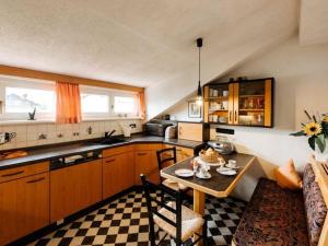 una piccola cucina con tavolo e divano di Chic holiday apartment a Oy-Mittelberg