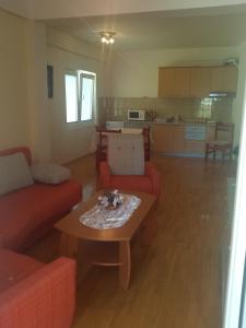 a living room with two red couches and a table at Gjole Apartments in Lagadin +25 photos