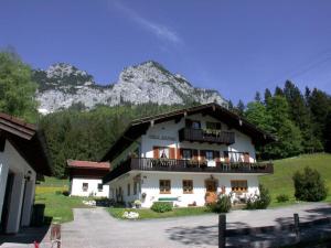 uma grande casa branca com uma montanha ao fundo em Haus Brandl Modern retreat em Ramsau