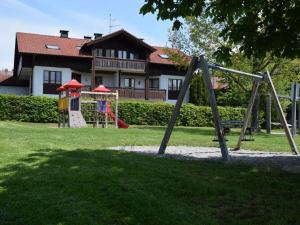 un parque infantil frente a una casa con un edificio en Holiday apartment Allgäuer Alpenblick en Rettenberg