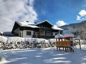una casa está cubierta de nieve con una casa en Holiday apartment Allgäuer Alpenblick en Rettenberg