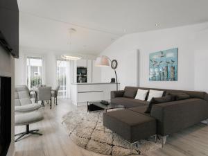 a living room with a couch and a table at Chalet in Zeeland by Scenic Pond in Wemeldinge