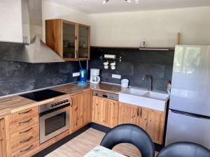 a kitchen with wooden cabinets and a sink and a refrigerator at Apartment Philipps 2 in Graach
