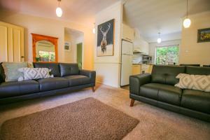 a living room with two black couches and a kitchen at Silver Birches Holiday Village - Unit 8 in Bright
