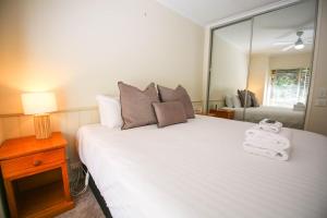 a bedroom with a large white bed with a mirror at Silver Birches Holiday Village - Unit 8 in Bright