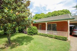 a red brick house with a white fence at Silver Birches Holiday Village - Unit 8 in Bright