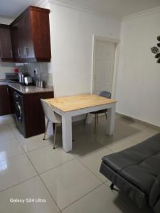 - une cuisine avec une table en bois dans une chambre dans l'établissement Durban Muslim Accomdation HALAAL SELF CATERING NO ALCOHOL 2 to 4 SLEEPER, 3 Adults only or 2 Adults plus 2 Small Kids, à Durban