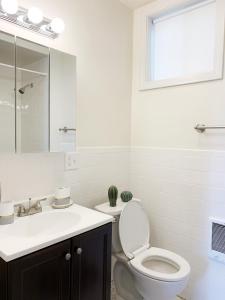 baño con aseo y lavabo y ventana en Best Location At Harvard University! 4 Bedroom Apartment! Two Units Available!, en Cambridge