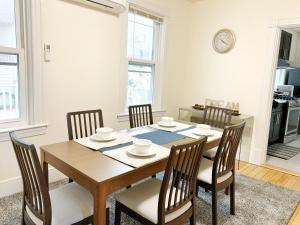 uma sala de jantar com uma mesa de madeira e cadeiras em Best Location At Harvard University! 4 Bedroom Apartment! Two Units Available! em Cambridge