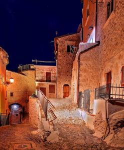 um beco numa cidade velha à noite em Appartamento nel cuore di Campo Imperatore em Castel del Monte