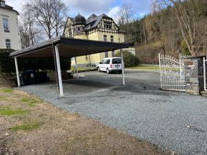 a building with a car parked in a parking lot at Ferienwohnung Marie in Bad Elster
