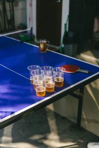 un tavolo da ping pong blu con tazze sopra di Zentiga Surf Hostel a Canggu