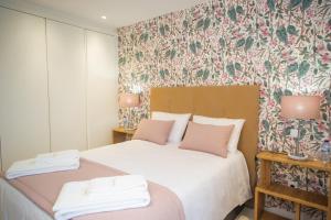 1 dormitorio con 2 camas y papel pintado con motivos florales en Batalha - Ferreiras Apartment en Batalha