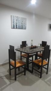 卡塔赫納的住宿－Aparta-estudio con hermosa vista，一张木桌、椅子、桌子和绘画作品