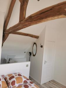 - une chambre avec un lit et un plafond en bois dans l'établissement Le p'tit coin dans les vignes, à Restigné