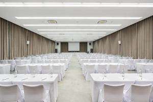 Cette grande chambre comprend des tables et des chaises blanches. dans l'établissement Koh Chang Paradise Hill, à Ko Chang