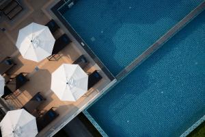 象島的住宿－Koh Chang Paradise Hill，享有带白色遮阳伞的游泳池的顶部景致