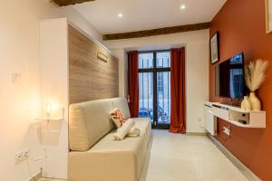 een woonkamer met een bank en een televisie bij Charmant Studio Neuf N•2 - Centre ville in Montpellier