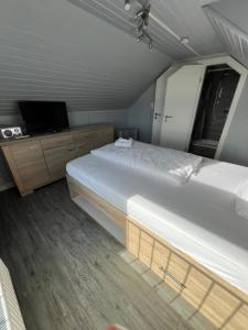 ein Schlafzimmer mit 2 Betten und einem TV. in der Unterkunft Hotel Tum Stüürmann in Büsum