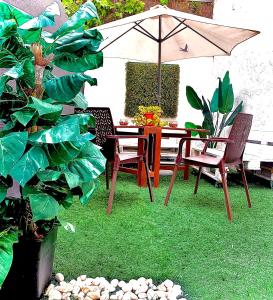 a table and chairs with an umbrella in a garden at Violeta loft A with chill out terrace Sevilla in Seville