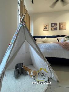 un cane che giace accanto a una tenda tenda tenda teepee in una camera da letto di Bali Residence Private Suites l Seaview I 4-5 pax l Kids Tent I 5 Mins to Jonker a Malacca