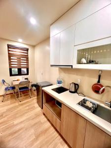 a kitchen with white cabinets and a table in it at HPT II Apartment chuỗi căn hộ Hải Phòng in Hai Phong