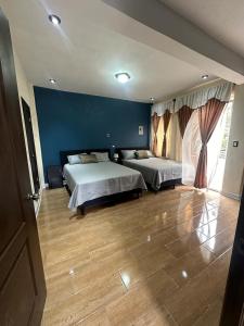 - une chambre avec 2 lits et un mur bleu dans l'établissement CASA DE DESCANSO TZANJAAY, à San Juan La Laguna